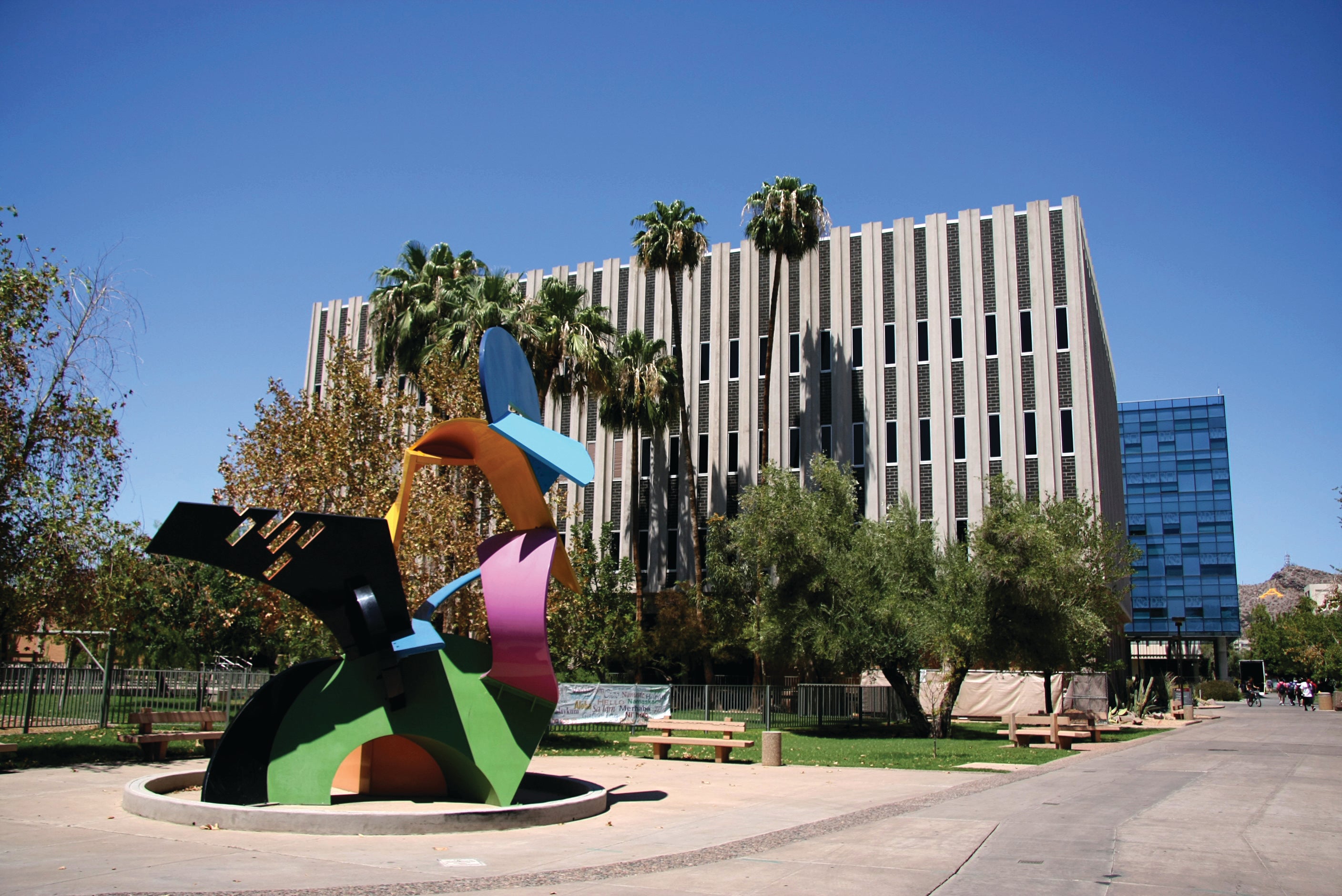 A colorful art sculpture sits in front of Payne Hall, a multi-story building 