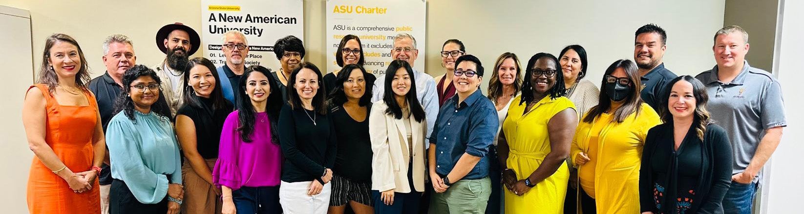 Group of School of Counseling and Counseling Psychology faculty members posing together indoors with ASU-related posters in the background.