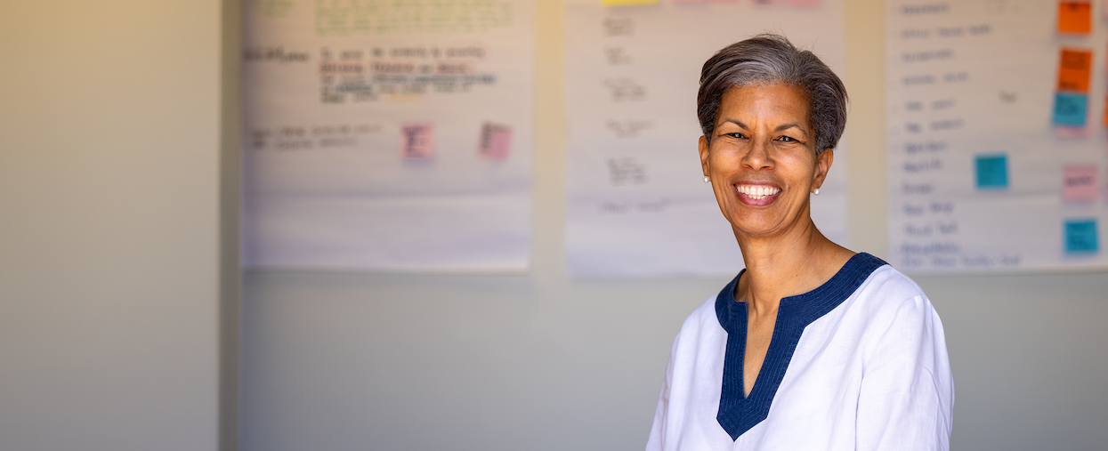 Wanda Wright, smiling in front of a bulletin board