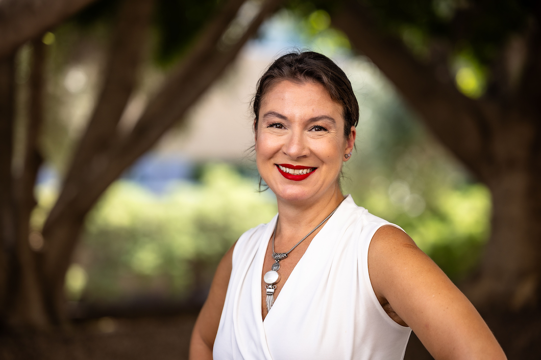 School of Counseling and Counseling Psychology dean Ayse Ciftici standing in front of a wooded background smiling