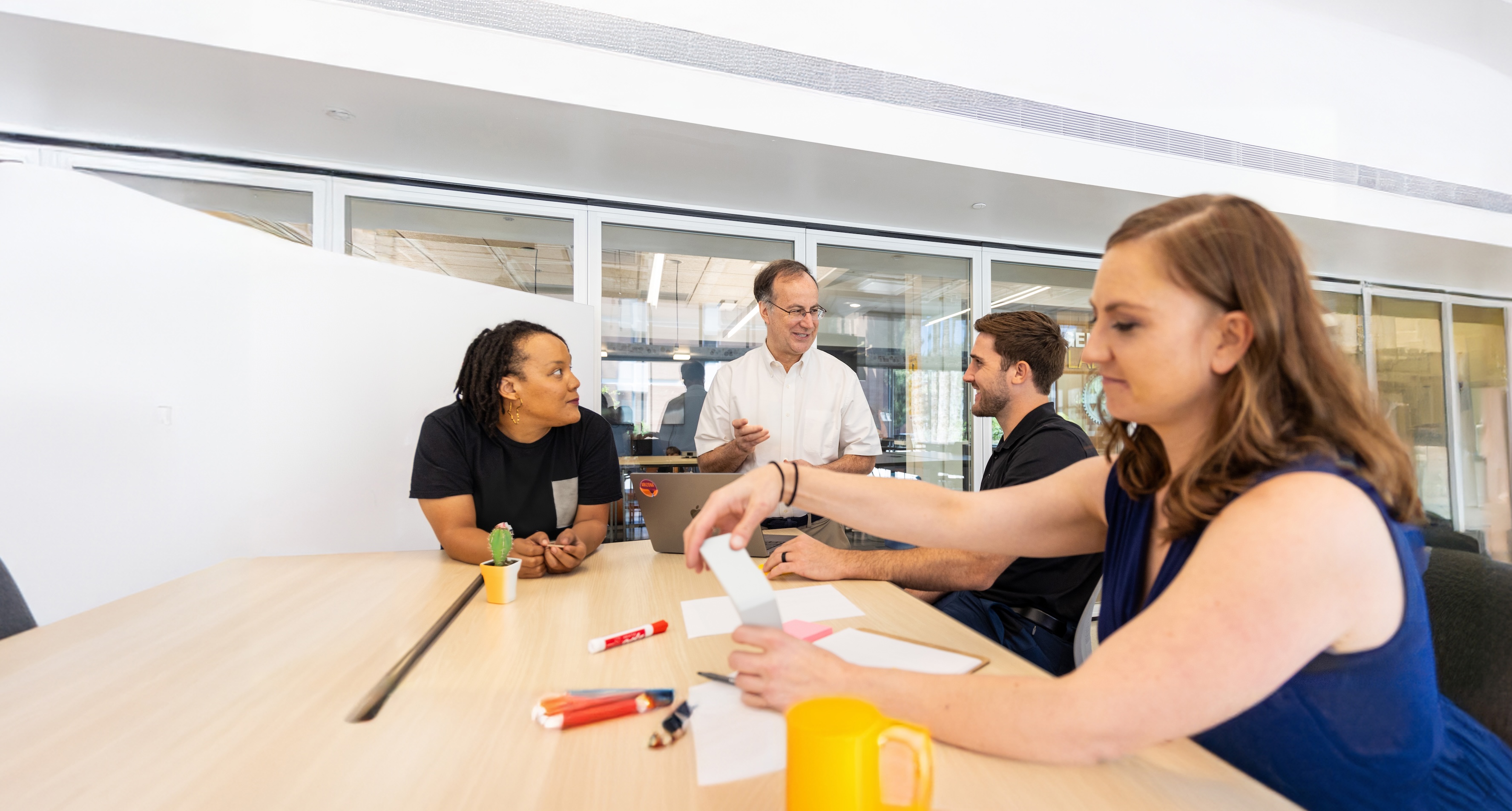 Group of people having a workshop on a large conference table in a conference room