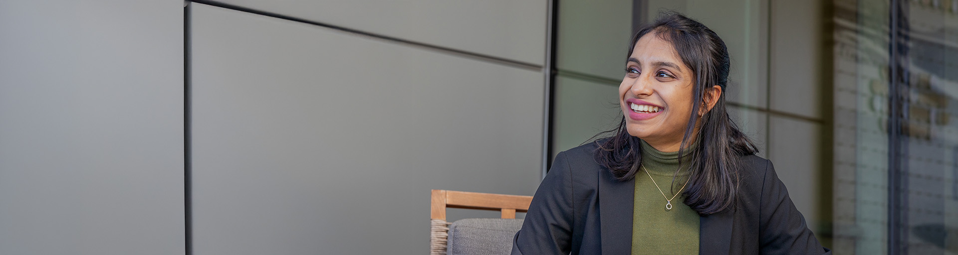 Woman sitting in an office building and smiling.