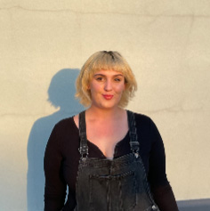 Asa Chambers, a young woman with dyed blonde hair standing in front of a brick wall.