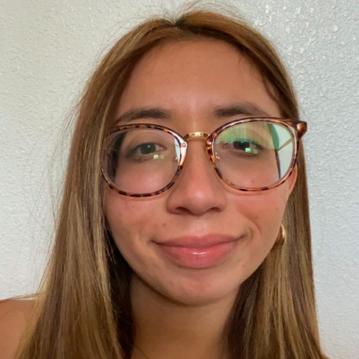Michelle Leal, a young woman with glasses smiling.