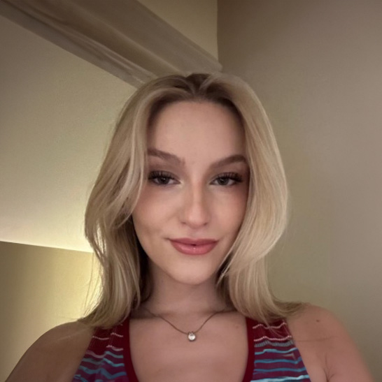 Jessica Leland, a young woman with blonde hair, wearing a striped top and a necklace and smiling.